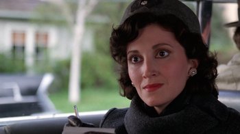 Movie still from “The Right Stuff” (1983), directed by Philip Kaufman – A person sitting in a car holding a pen; Close Up shot, Low angle