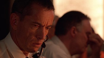 Movie still from “The Right Stuff” (1983), directed by Philip Kaufman – A man wearing a headset in front of another man; Close Up shot, Low angle