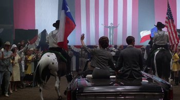 Movie still from “The Right Stuff” (1983), directed by Philip Kaufman – A group of people sitting on top of a horse; Wide shot, High angle