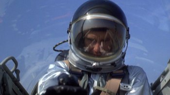 Movie still from “The Right Stuff” (1983), directed by Philip Kaufman – A man in a spacesuit is looking at the camera; Close Up shot, Low angle