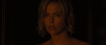Movie still from “The Road” (2009), directed by John Hillcoat – Charlize theron in a dark room with her eyes closed; Close Up shot, High angle
