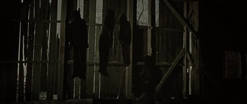 Movie still from “The Road” (2009), directed by John Hillcoat – A group of people hanging from the side of a building; Wide shot, Low angle