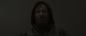 Movie still from “The Road” (2009), directed by John Hillcoat – A man with a beard wearing a hooded jacket; Close Up shot, Low angle