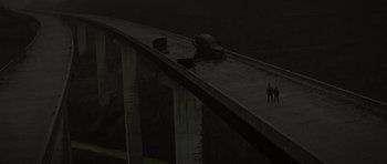 Movie still from “The Road” (2009), directed by John Hillcoat – Two people are standing on the side of a bridge; Extreme Wide shot, Overhead angle