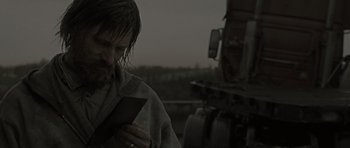 Movie still from “The Road” (2009), directed by John Hillcoat – A man standing next to a truck in the rain; Close Up shot, Over the shoulder angle