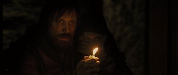 Movie still from “The Road” (2009), directed by John Hillcoat – A man and woman holding a candle in the dark; Close Up shot, Over the shoulder angle