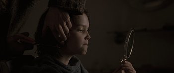 Movie still from “The Road” (2009), directed by John Hillcoat – A person is combing the hair of a woman; Close Up shot, Over the shoulder angle