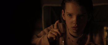 Movie still from “The Road” (2009), directed by John Hillcoat – A young girl is holding a wine glass in her hand; Close Up shot, Over the shoulder angle