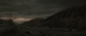 Movie still from “The Road” (2009), directed by John Hillcoat – A dark picture of a mountain with a dark sky; Extreme Wide shot, High angle