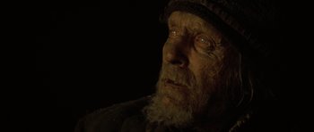 Movie still from “The Road” (2009), directed by John Hillcoat – An old man with a beard wearing a hat; Close Up shot, Over the shoulder angle