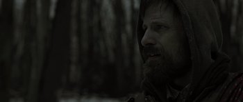 Movie still from “The Road” (2009), directed by John Hillcoat – A man with a beard and a hooded jacket; Close Up shot, Over the shoulder angle