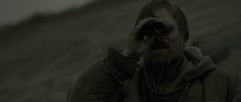 Movie still from “The Road” (2009), directed by John Hillcoat – A man looking through a pair of binoculars; Close Up shot, Over the shoulder angle