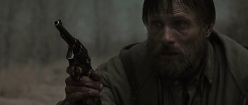 Movie still from “The Road” (2009), directed by John Hillcoat – A person holding a gun; Close Up shot, Low angle