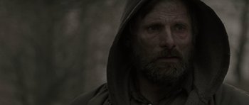 Movie still from “The Road” (2009), directed by John Hillcoat – A man with a beard and a hooded jacket; Close Up shot, Over the shoulder angle