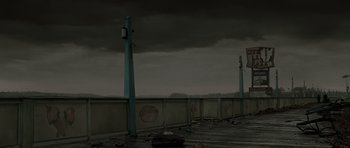 Movie still from “The Road” (2009), directed by John Hillcoat – A pier that has some graffiti on it; Wide shot, High angle