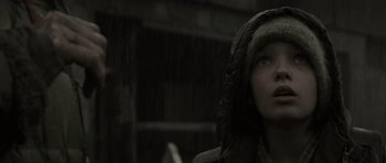 Movie still from “The Road” (2009), directed by John Hillcoat – A person standing in the rain wearing a hood; Close Up shot, Low angle