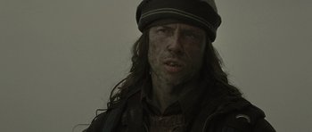 Movie still from “The Road” (2009), directed by John Hillcoat – A person with long hair wearing a hat; Close Up shot, Low angle