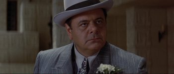 Movie still from “The Rocketeer” (1991), directed by Joe Johnston – A person wearing a suit and a hat; Close Up shot, Over the shoulder angle