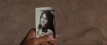 Movie still from “The Rocketeer” (1991), directed by Joe Johnston – A person holding up an old photo of a woman; Extreme Close Up shot, Overhead angle