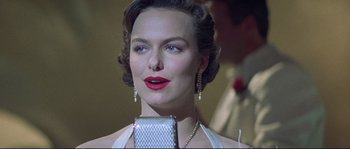 Movie still from “The Rocketeer” (1991), directed by Joe Johnston – A beautiful woman with red lipstick is holding a microphone; Close Up shot, Low angle