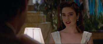 Movie still from “The Rocketeer” (1991), directed by Joe Johnston – A woman in a white dress sitting in front of a fountain; Close Up shot, Over the shoulder angle