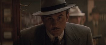 Movie still from “The Rocketeer” (1991), directed by Joe Johnston – A man in a suit and a hat looking to his left; Close Up shot, Low angle