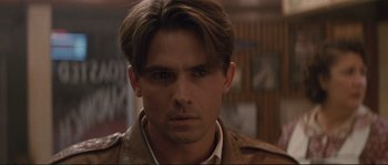 Movie still from “The Rocketeer” (1991), directed by Joe Johnston – A person wearing a brown jacket; Close Up shot, Over the shoulder angle