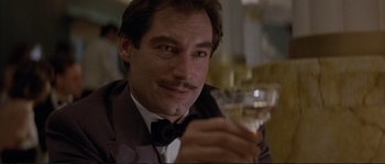 Movie still from “The Rocketeer” (1991), directed by Joe Johnston – A person holding a glass of wine; Close Up shot, Low angle