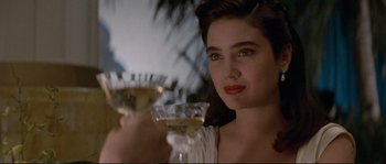 Movie still from “The Rocketeer” (1991), directed by Joe Johnston – A woman holding a glass of wine in her hand; Close Up shot, Over the shoulder angle