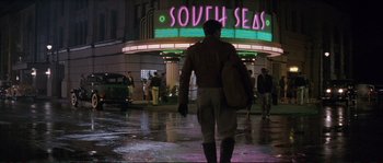 Movie still from “The Rocketeer” (1991), directed by Joe Johnston – A man walking in the rain in front of a theater; Wide shot, Low angle