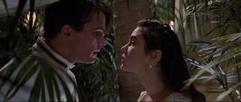 Movie still from “The Rocketeer” (1991), directed by Joe Johnston – A man and a woman looking at each other in front of a tree; Close Up shot, Over the shoulder angle