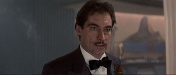 Movie still from “The Rocketeer” (1991), directed by Joe Johnston – A person wearing a suit and bow tie; Close Up shot, Low angle