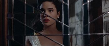 Movie still from “The Rocketeer” (1991), directed by Joe Johnston – A woman with red lipstick looking out a window; Close Up shot, Over the shoulder angle