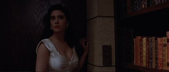 Movie still from “The Rocketeer” (1991), directed by Joe Johnston – A woman in a white dress standing next to a wall; Close Up shot, Low angle