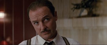 Movie still from “The Rocketeer” (1991), directed by Joe Johnston – A man with a mustache wearing a tie; Close Up shot, Low angle