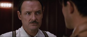 Movie still from “The Rocketeer” (1991), directed by Joe Johnston – A man with a mustache wearing a tie; Close Up shot, Low angle