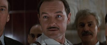 Movie still from “The Rocketeer” (1991), directed by Joe Johnston – A person wearing a suit and tie; Close Up shot, Low angle