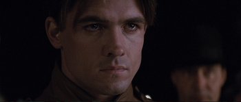 Movie still from “The Rocketeer” (1991), directed by Joe Johnston – Close up of a man's face in a dark room; Close Up shot, Low angle