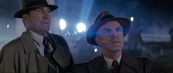 Movie still from “The Rocketeer” (1991), directed by Joe Johnston – A man in a hat and a suit and tie; Close Up shot, Low angle