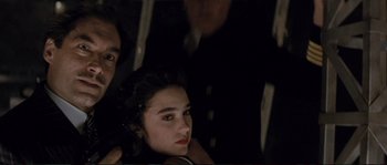 Movie still from “The Rocketeer” (1991), directed by Joe Johnston – A woman sitting next to a man in a dark room; Close Up shot, Over the shoulder angle