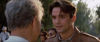 Movie still from “The Rocketeer” (1991), directed by Joe Johnston – A man with a beard is talking to another man; Close Up shot, Over the shoulder angle