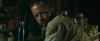 Movie still from “The Rover” (2014), directed by David Michôd – A man with a goatee and beard is looking at the camera; Close Up shot, Low angle