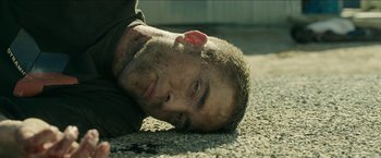 Movie still from “The Rover” (2014), directed by David Michôd – A person laying on the ground; Close Up shot, High angle