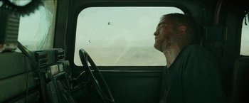 Movie still from “The Rover” (2014), directed by David Michôd – A man sitting in the driver's seat of a car; Close Up shot, Over the shoulder angle