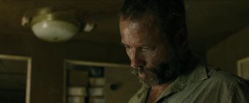 Movie still from “The Rover” (2014), directed by David Michôd – A person with a beard; Close Up shot, Low angle