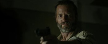 Movie still from “The Rover” (2014), directed by David Michôd – A person holding a gun; Close Up shot, Low angle