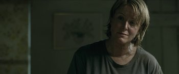 Movie still from “The Rover” (2014), directed by David Michôd – A woman with short hair is looking at the camera; Close Up shot, Over the shoulder angle