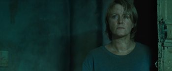 Movie still from “The Rover” (2014), directed by David Michôd – A woman standing in front of a wall; Close Up shot, Low angle