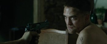 Movie still from “The Rover” (2014), directed by David Michôd – A person holding a gun; Close Up shot, Over the shoulder angle