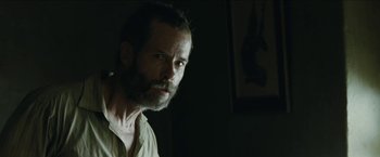 Movie still from “The Rover” (2014), directed by David Michôd – A man with a goatee is looking at the camera; Close Up shot, Low angle